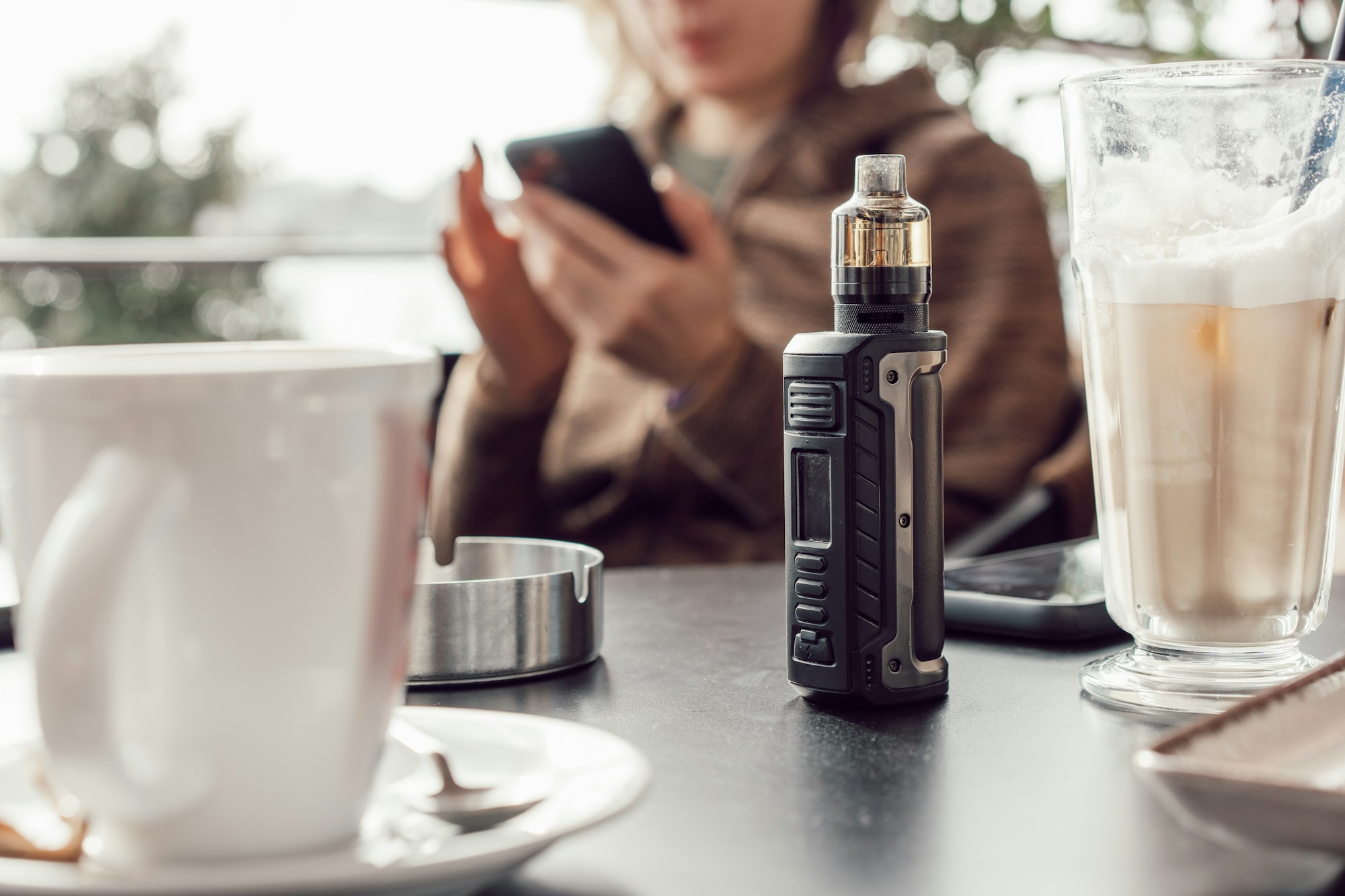 Vape stands on a wooden table in cafe